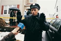 a policeman turning back reporters